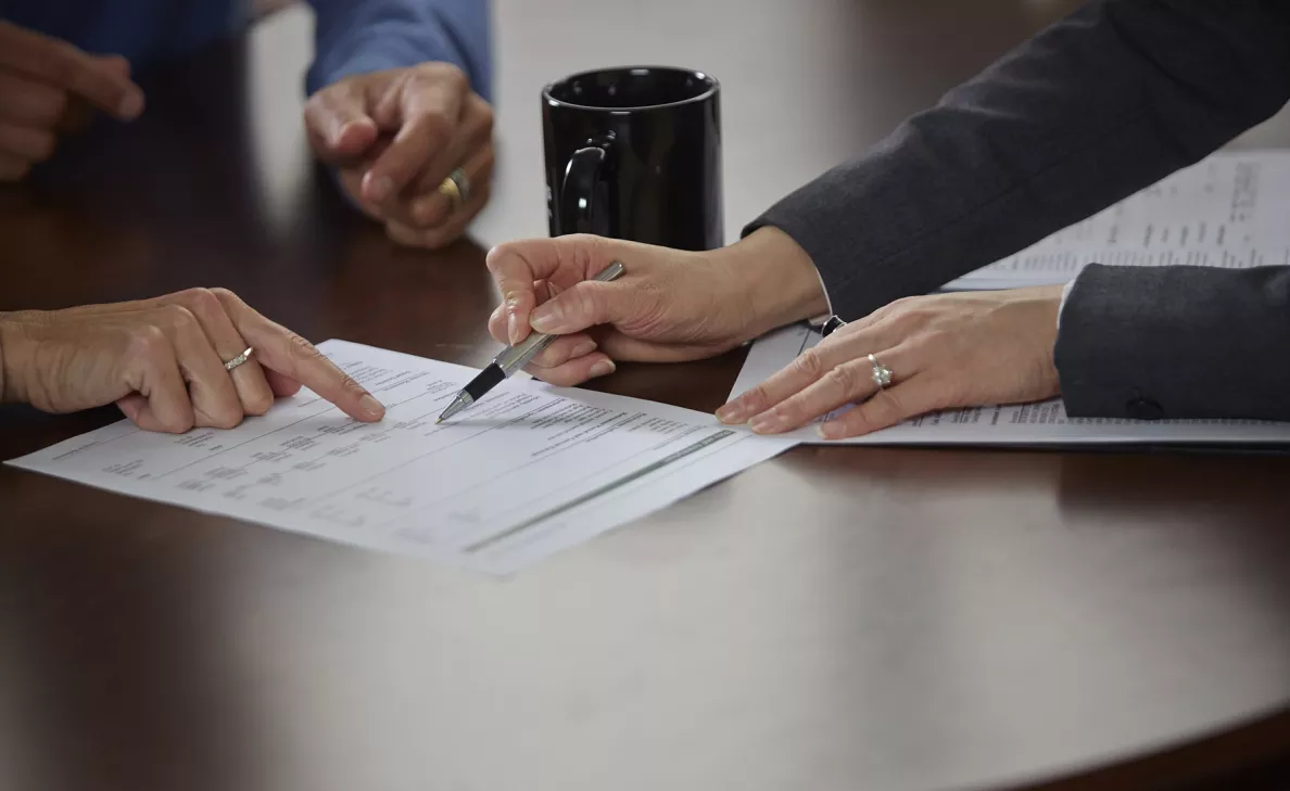  An Edward Jones analyst discusses financial reports with two clients at their Boston, Massachusetts office.
