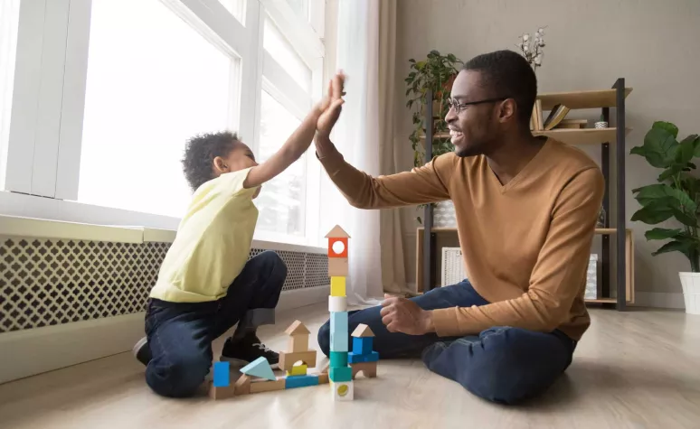 Father and child enjoy playing block games